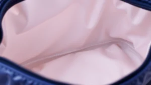 Close-up of Longchamp nylon cosmetic bag interior lining with soft fabric texture, professional lighting showing quality construction details and stitching