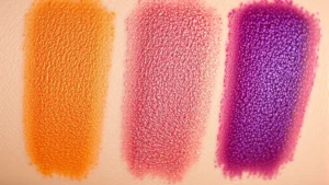 Close-up of vibrant eyeshadow palette swatches showing bold pigmentation and shimmer finishes, arranged on fair and deep skin tones, natural lighting highlighting color intensity and texture